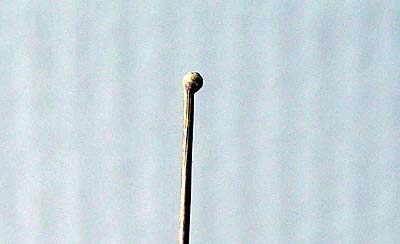 Капля на конце латунной проволоки